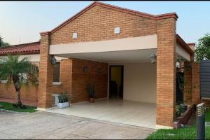 a brick house with a large garage at Casa en condominio a 3 minutos del Aeropuerto in Luque