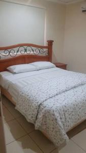 1 dormitorio con 1 cama con edredón blanco en Casa en condominio a 3 minutos del Aeropuerto, en Luque