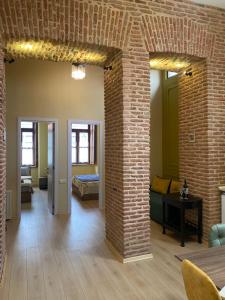 a living room with a brick wall and a bed at Historic Apartments "1868 Tbilisi" Best Location in Tbilisi City