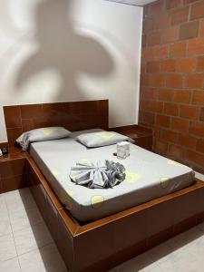 Hostal Portal del Sol في Jamundí: سرير في غرفة بجدار من الطوب