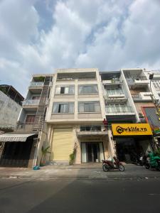 un immeuble d'appartements avec une moto garée devant celui-ci dans l'établissement Ngọ house, à Hô-Chi-Minh-Ville