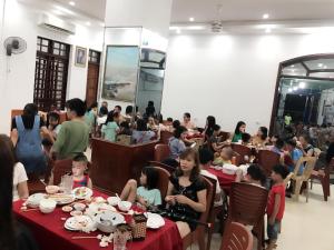 a group of children sitting at tables in a restaurant at Hai Hoa Hotel in Cửa Lò
