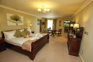 a bedroom with a large bed and a dining room at Torc Hotel in Killarney