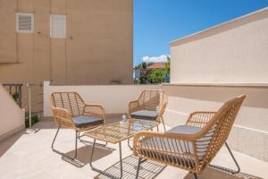 a group of chairs and a table on a balcony at Apartments Mari - 40m from the beach in Makarska