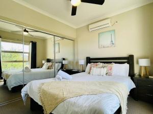a bedroom with two beds and a large mirror at Tranquil Retreat near to Airport in Melbourne