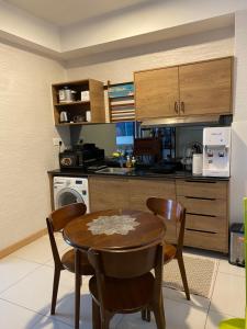 a kitchen with a table and chairs in a room at Timurbay Seafront Residence aRRayyan Suites in Kuantan