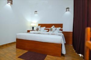 a bedroom with a large bed with white sheets at Blooming Holiday Resort in Anuradhapura