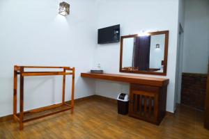 y baño con espejo y tocador de madera. en Blooming Holiday Resort, en Anuradhapura