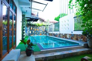 a swimming pool in the backyard of a building at Blooming Holiday Resort in Anuradhapura