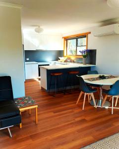 uma cozinha com mesa e cadeiras num quarto em Percy's Cottage em Devonport