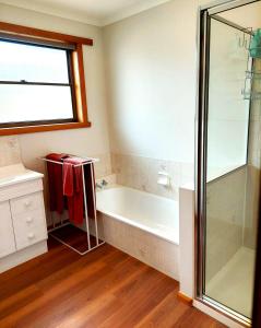 a bathroom with a bath tub and a shower at Percy's Cottage in Devonport