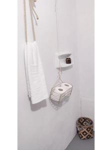 a white bathroom with a towel rack and a basket at Town House with Rooftop Jacuzzi in Rhodes Town