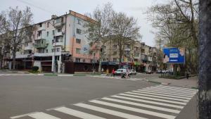 uma rua com uma faixa de pedestres numa cidade com edifícios em Sunday em Chornomorsk