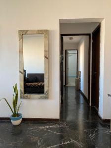 einen Flur mit einem Spiegel an einer weißen Wand in der Unterkunft Confortcentro in Mendoza