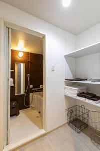 a bathroom with a glass door leading into a room at Shinosaka private house for 16ppl in Osaka