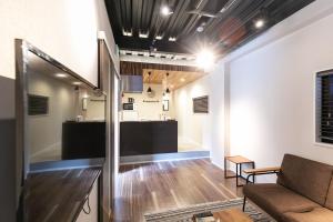 a living room with a couch and a counter at Shinosaka private house for 16ppl in Osaka