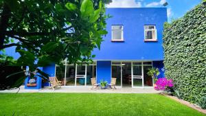 a blue house with chairs and a yard at Casa Tamayo in Mexico City