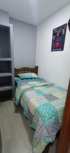 Dormitorio con cama y póster en la pared en Encantadora habitacion en casa de huéspedes 2 en Soledad