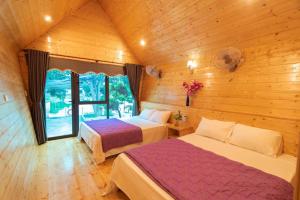 a bedroom with two beds in a wooden cabin at Cô Tô Lương Chi in Quang Ninh +43 photos