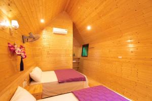 um quarto com 2 camas num quarto de madeira em Cô Tô Lương Chi em Quang Ninh