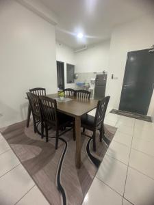 uma mesa de jantar e cadeiras numa cozinha em IQ Homestay Cybersouth with Swimming Pool em Kampung Dengkil