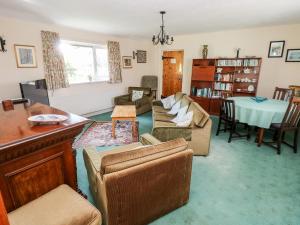 a living room with couches and a table at Otter Cottage in Newport Pembrokeshire