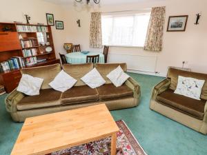 a living room with two couches and a table at Otter Cottage in Newport Pembrokeshire