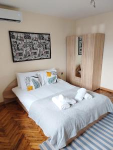 a bedroom with a large white bed with towels on it at Apartment Zdravets in Veliko Tŭrnovo