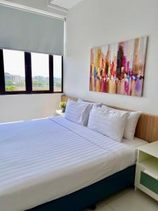 a bedroom with a bed with a painting on the wall at PadiViu Family Suite at Imperio Professional Suite, Alor Setar in Alor Setar