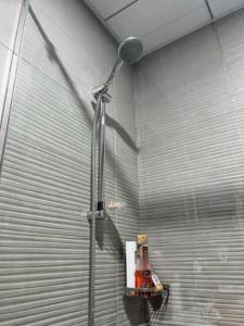 a shower in a room with a metal wall at Cozy studio, amazing amenities in Dubai