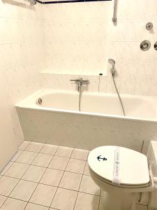 a bathroom with a toilet and a bath tub at Sonnendeck 3 in Zingst