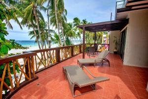 un balcón con sillas y una mesa y la playa en Red Coconut Beach Hotel Boracay en Boracay