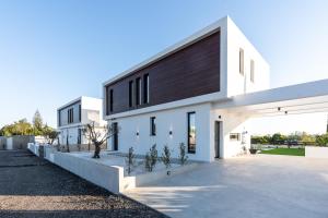 Biały dom z czarnym dachem w obiekcie Tsiolakki Homes Luxury Villas w mieście Protaras
