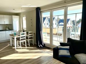 a living room with a table and a kitchen with a view at Sonnendeck 3 in Zingst