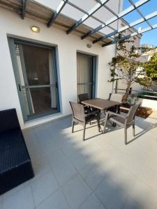 an outdoor patio with a wooden table and chairs at Notos Guesthouse in Monemvasia