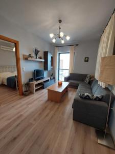 a living room with a couch and a table and a bed at Notos Guesthouse in Monemvasia