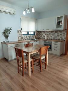 a kitchen with a wooden table and chairs at Notos Guesthouse in Monemvasia