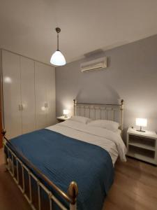 a bedroom with a large bed with a blue blanket at Notos Guesthouse in Monemvasia