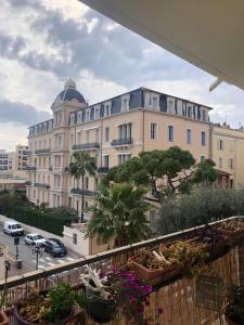 a view of a building with potted plants on a balcony at Plein centre de Beaulieu in Beaulieu-sur-Mer