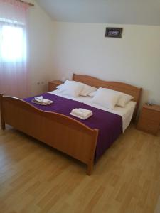 een slaapkamer met een groot bed en 2 handdoeken bij Apartment Supetar Sunset View in Supetar