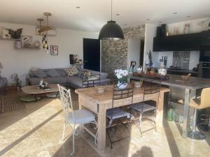 a kitchen and living room with a wooden table and chairs at Superbe Villa en Provence 85 m2 in Puimichel