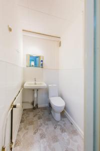 La salle de bains blanche est pourvue de toilettes et d'un lavabo. dans l'établissement YH Lappeenranta, à Lappeenranta