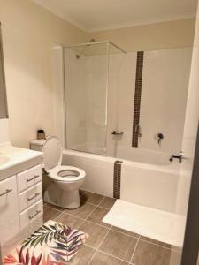 a white bathroom with a toilet and a shower at Townhouse in Franklin in Harrison