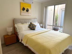 a bedroom with a bed with a yellow blanket and a window at Townhouse in Franklin in Harrison
