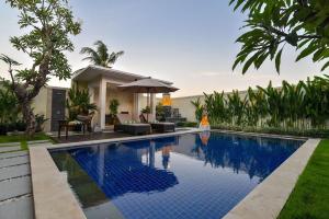 a swimming pool in front of a house at Banyu Riris Villa Lovina Private Villa in Banjar