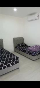 two beds are sitting in a room with at Lanai Meranti in Ipoh