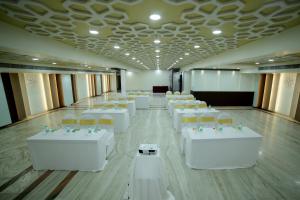a large room with white tables and chairs in it at Raj Park- Hill View in Tirupati