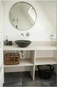 een badkamer met een wastafel en een spiegel bij Mooi, vrij gelegen vakantiehuis dichtbij zee en strand! in Aagtekerke