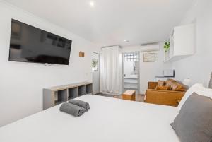 a white bedroom with a large bed and a living room at Pet Room at Moody's in Blairgowrie