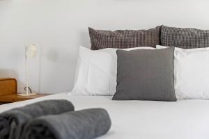 a white bed with white pillows and a gray pillow at Pet Room at Moody's in Blairgowrie